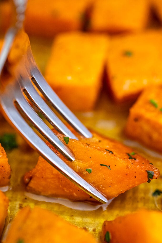 a fork pinching a cubed Roasted Sweet Potato