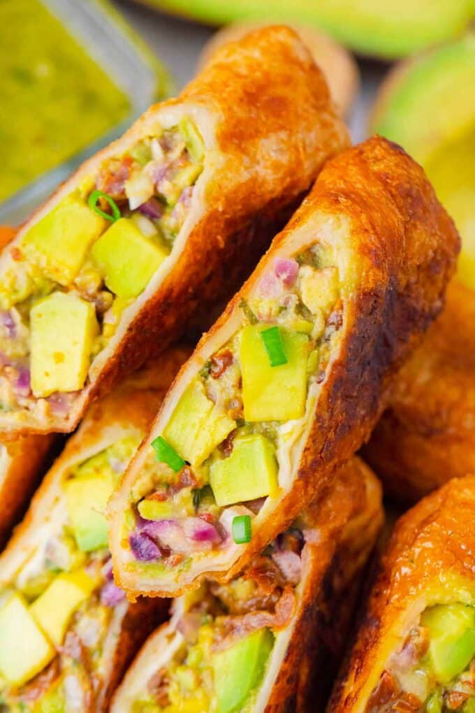 Close shot of sliced homemade cheesecake factory avocado egg rolls revealing avocado filling.